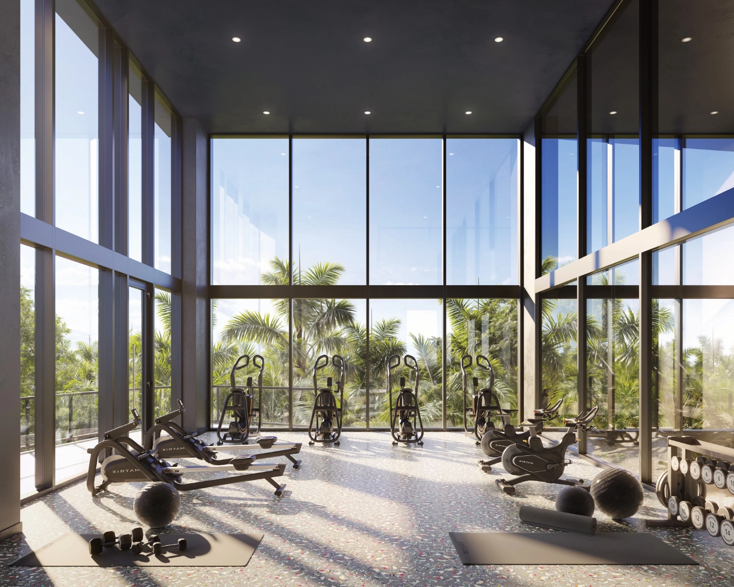 Residents gym at the Mondrian Hallandale Beach Residences with cardio equipment and free weights with large windows.