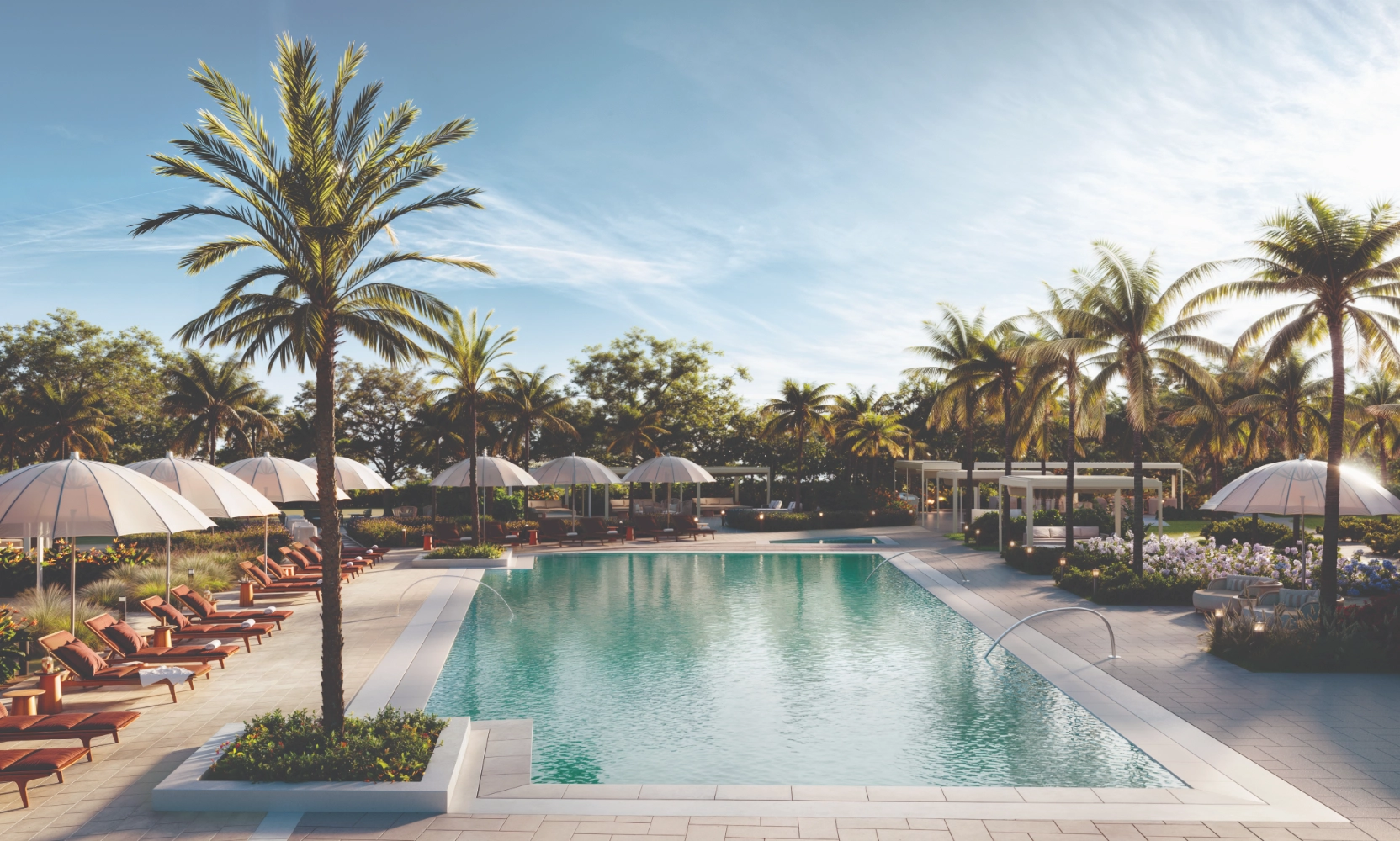 Resort-style pool at the Mondrian Hallandale Beach Residences with covered lounge seating and palm trees for shade.